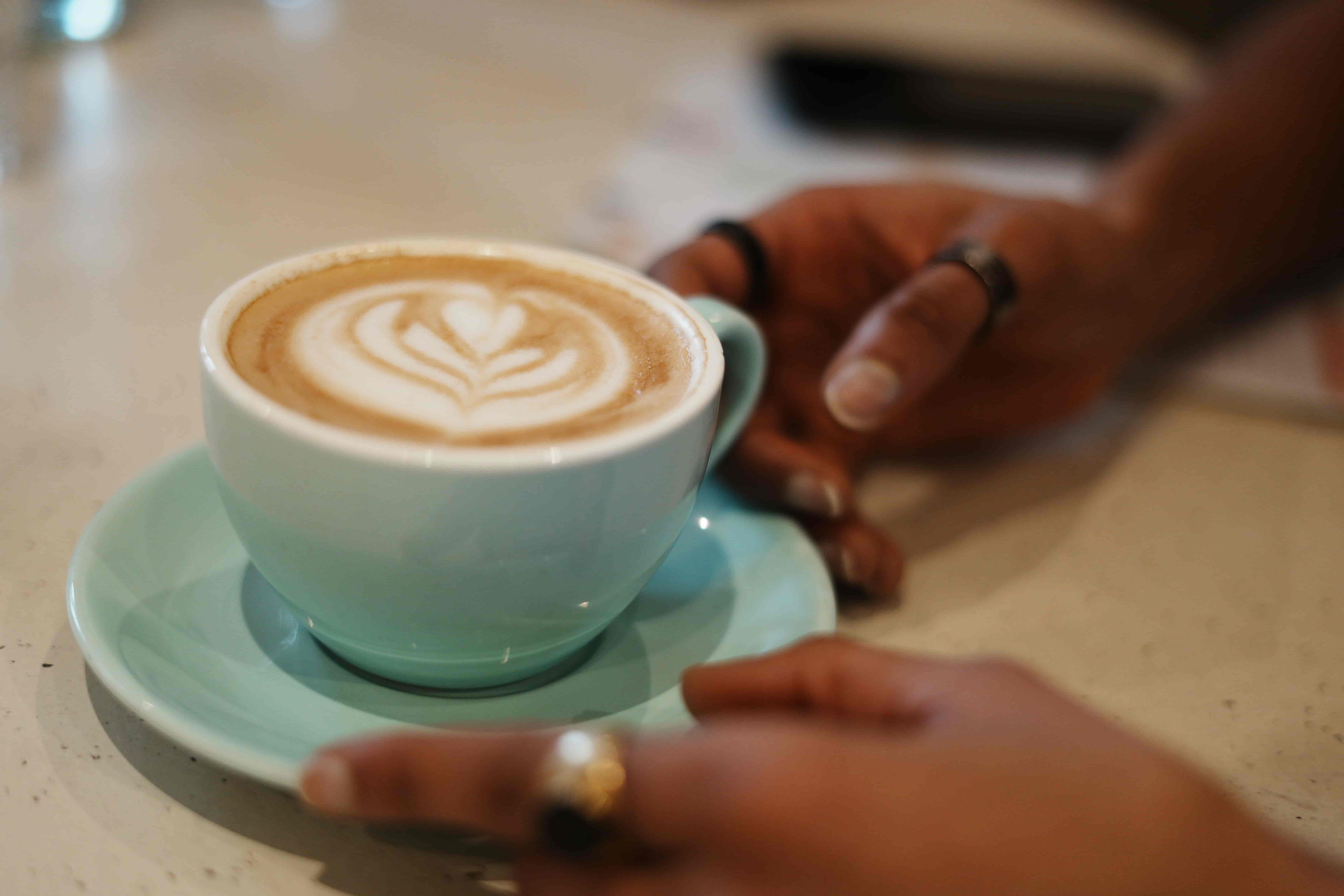 Cappuccino mit Latte Art und Kaffeebohnen